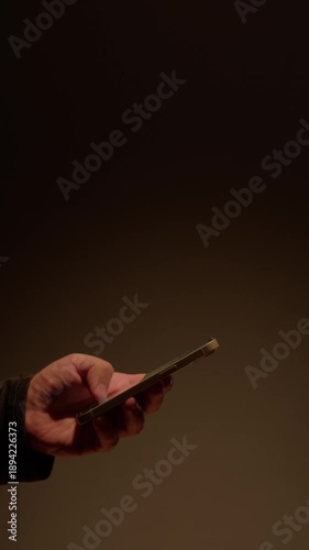 Phone at night, Close-up macro hands of a man scroll news feed on mobile phone app application. Screen of the mobile phone illuminates male hand. 