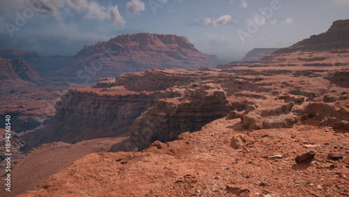 Stunning red rock formations rise dramatically against a clear sky, illuminated by the warm afternoon sun. The expansive landscape invites exploration and adventure amidst natures beauty.