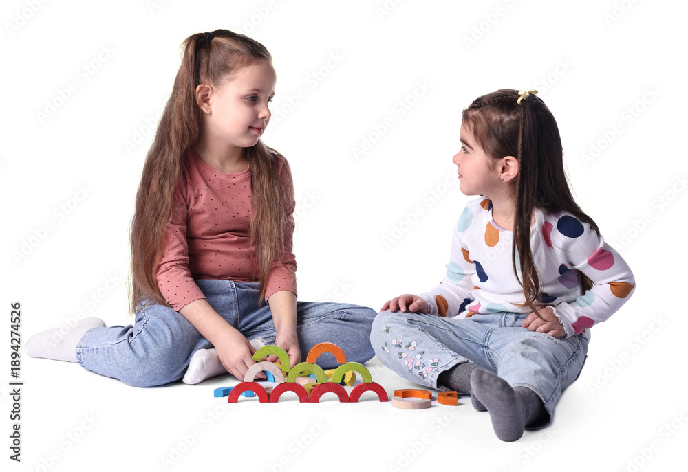 Fototapeta premium Cute little girls playing with colorful wooden pieces on white background