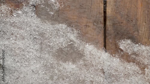 Melting Ice and Snow on Wooden Surface in Early Spring, Close-Up Texture