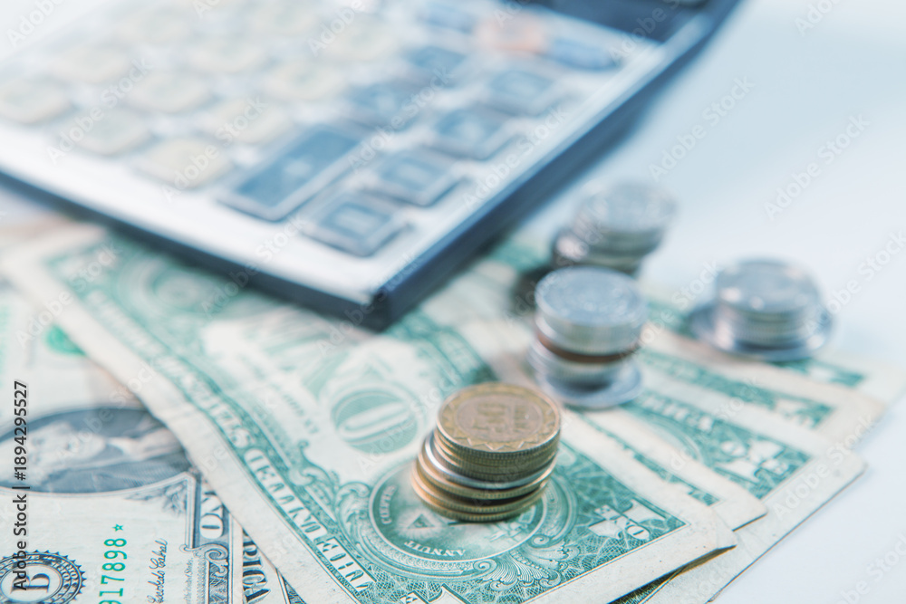Fototapeta premium calculator and coins on the table, business concept of saving money