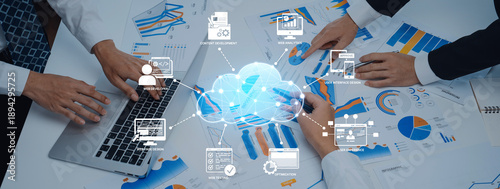 Foto Business professionals engage in collaboration over data analysis with charts and laptop in a modern workspace, illustrating the impact of cloud technology in teamwork