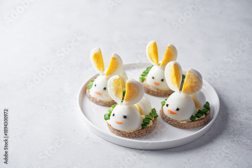 Bread with mayonnaise sauce and boiled egg in the form of rabbit in a plate for Easter holidays