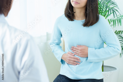 Fotografie 病院で診察を受ける女性　腹痛　体調不良