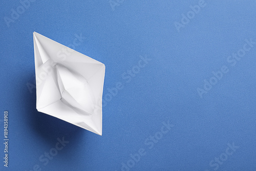 White paper boat on blue ba...