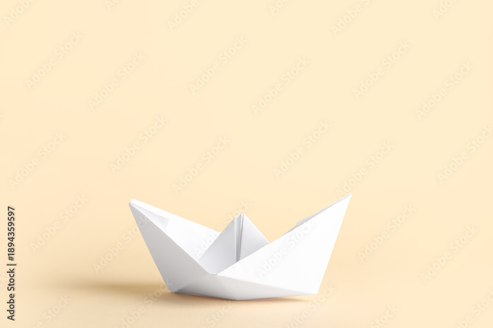 Naklejka premium White paper boat on beige background