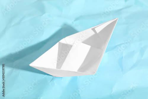 White paper boat on blue ba...