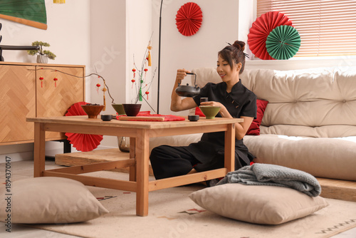 Young Asian woman pouring t...