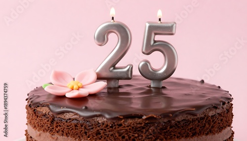 A delicious chocolate cake with lit number 25 candles for a special celebration