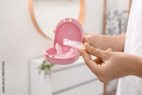 Tableau sur toile Woman and box with occlusal splint in bathroom, closeup