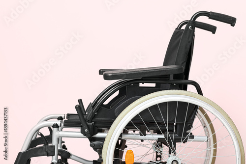 Empty wheelchair on pink ba...