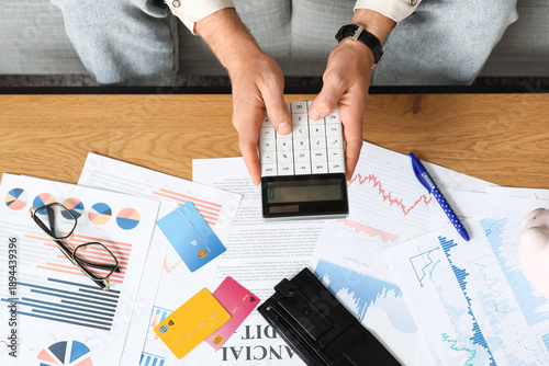 Young man in debt using cal...