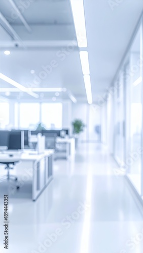 Blurred modern office interior with desks and natural light, creating a serene and spacious work environment.