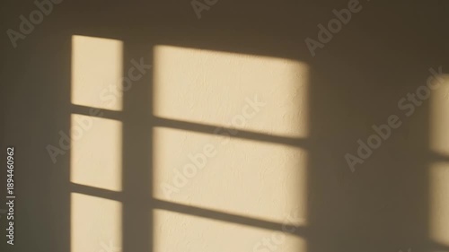 Shadows of a window on a wall, creating a beautiful pattern in the sunlight.