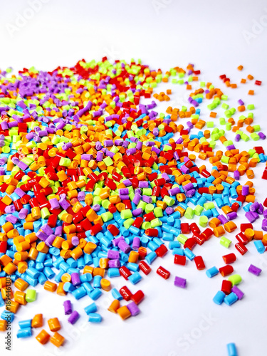 Colorful masterbatch granules are poured into a white background, the video surrounds the cold cutting type masterbatch, as a videography design for an industrial plastic company