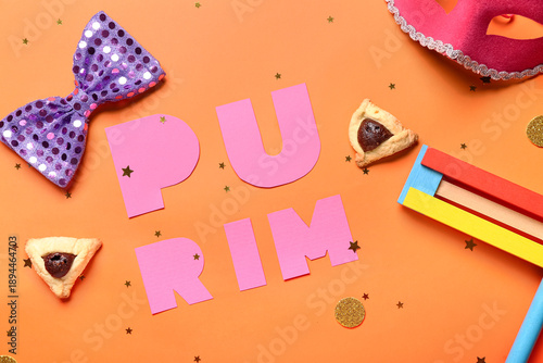 Composition with word PURIM, Hamantaschen cookies and decor on color background