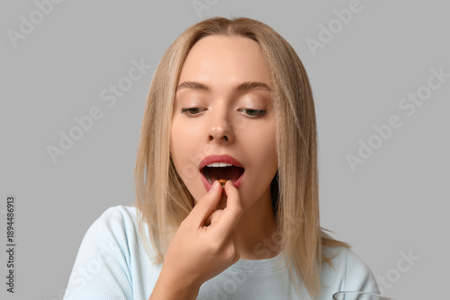 Young woman taking vitamin ...