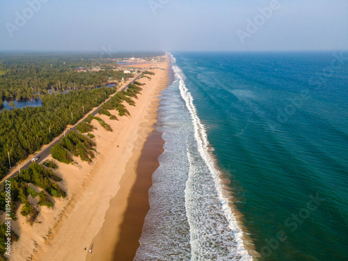 Aerial drone view of Puri Konark Marine Drive coastline in Odisha, India, showing long sandy beach, blue ocean waves, tropical greenery, and scenic coastal landscape
