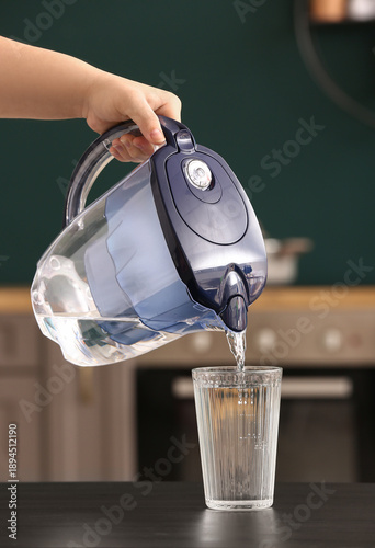 Woman pouring water from fi...