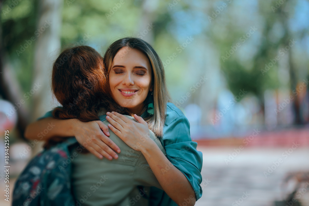 Fototapeta premium Happy Woman Hugging Her Best Friend on the Street. Acquaintances greeting each other on the street with enthusiasm and a hug