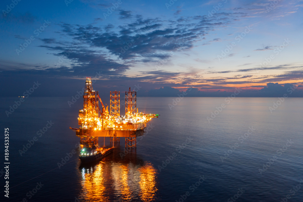 Obraz premium Aerial view of offshore jack up rig in a shipyard during sunset for oil and gas exploration and production.