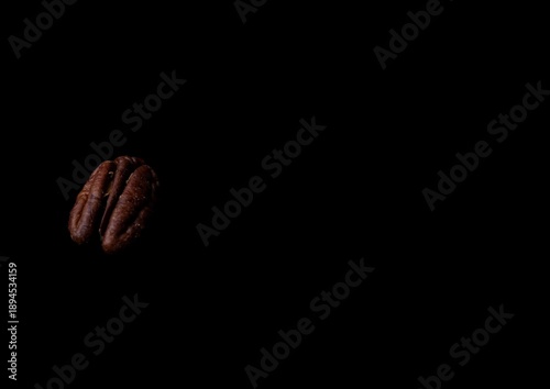 Heap of organic pecan nut kernels isolated on dark background