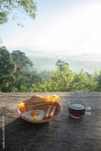 Breakfast of sausages mixed with fried eggs and bread served with coffee in the morning on an Asian-style plate