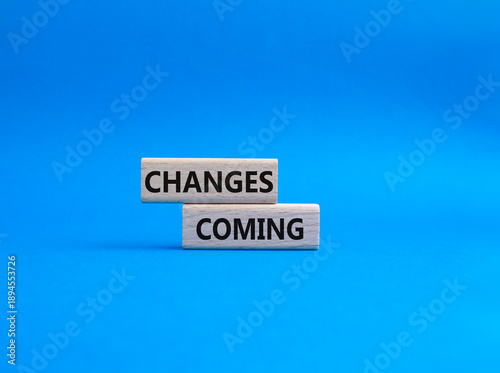 Changes Coming symbol. Wooden blocks with words Changes Coming. Beautiful blue background. Health and Changes Coming concept. Copy space.