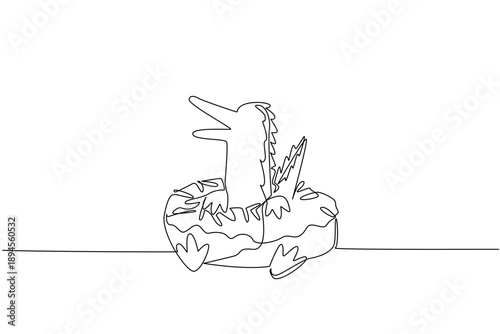 Continuous line drawing of playful crocodile shows cute animal lying inside donut with sprinkle for dessert concept. Unique design features swamp reptile for an international food day in minimalist