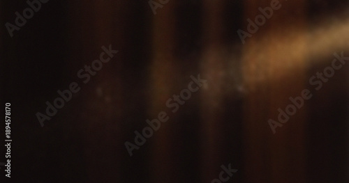 Fotografi Abstract motion blur with warm orange and brown vertical streaks on dark backgro