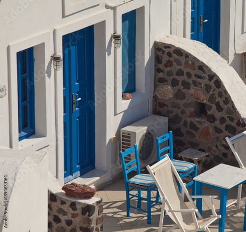 Konstfotografi Traditional whitewashed Greek patio with blue doors and chairs, Santorini