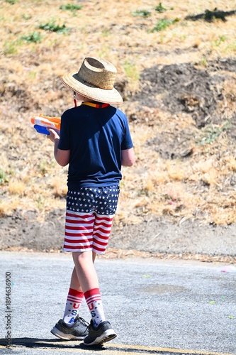 Boy with a Squirt Gun Dressed in Red, White and Blue USA Clothing on July 4th