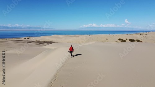 People walking through the desert, aerial photography, view of the dunes from above
