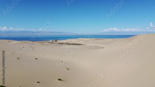People walking through the desert, aerial photography, view of the dunes from above
