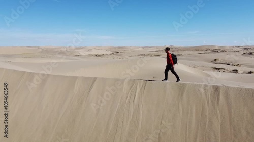 People walking through the desert, aerial photography, view of the dunes from above
