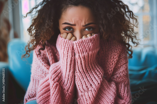 Young Woman Feeling Anxious and Sad Hiding Behind Pink Sweater.