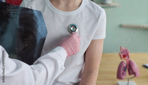 Obraz na płótnie Doctor uses stethoscope on patient during a medical examination in a clinic