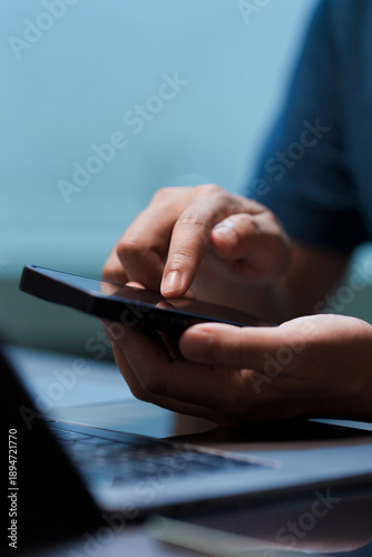 Canvas Print Close-up of hand holding a smartphone, finger touching the screen