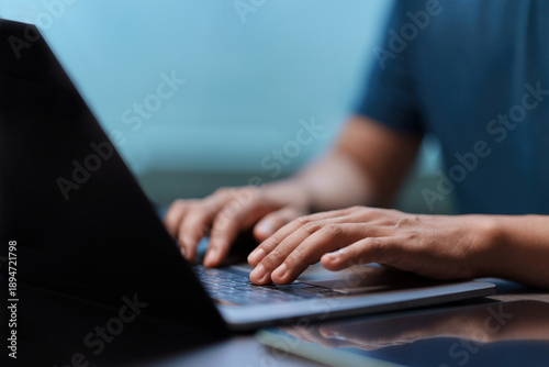Close-up of hands typing on a laptop keyboard. Concept for business, remote work, programming, or freelance lifestyle. Man working with modern technology in an office or home environment. Searching.