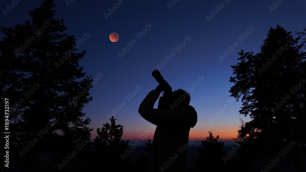 Fototapeta premium Amateur astronomer using binoculars for observing stars, planets, Moon and other celestial objects.