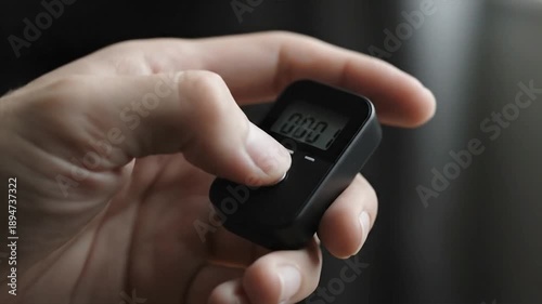 Wallpaper Mural Hand holding black electronic device with digital display showing numbers Torontodigital.ca