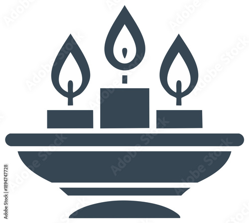 Three lit candles burning on a dark bowl shaped stand
