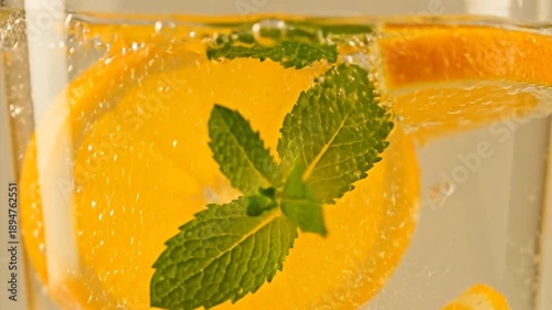 Refreshing citrus drink with mint and bubbles close up view