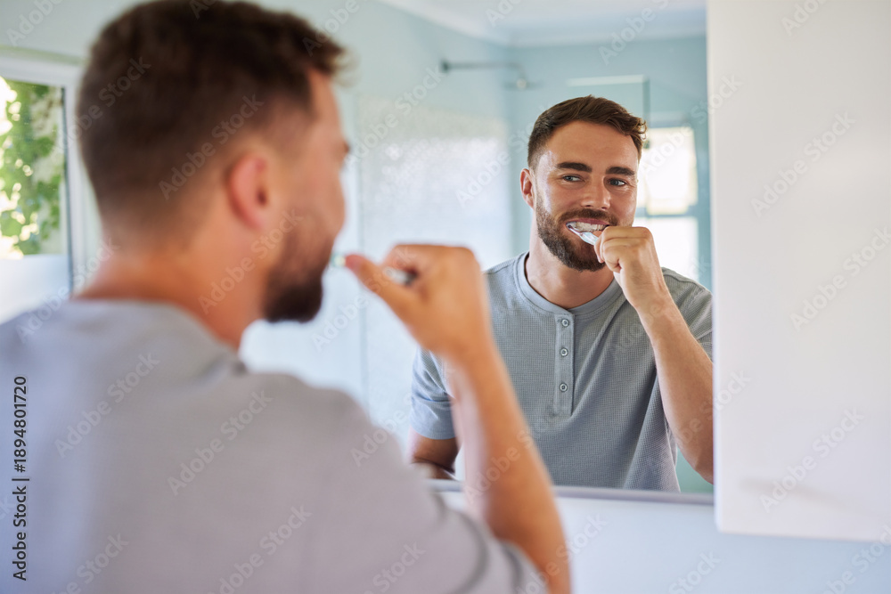 Fototapeta premium Man brushing teeth during morning routine