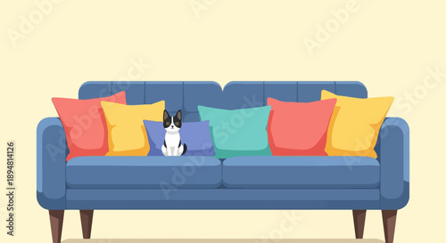 A small black and white cat sits on a blue couch with colorful pillows