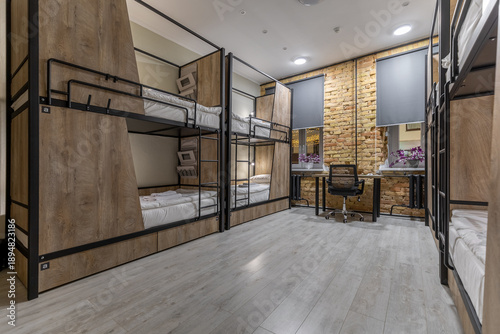 Modern loft hostel dormitory interior with bunk beds at night