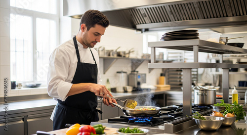 Chef cooking in commercial kitchen with vegetables and utensils