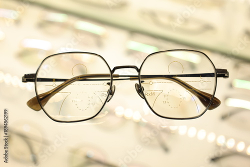 Eyeglasses on table, progressive lenses, eyeglasses for the elderly, glasses progressive lens, eyeglass progressive lens, close-up of glasses on lenses test, looking through glasses