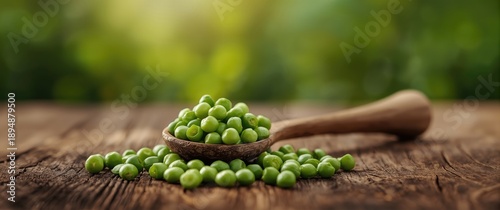 Wooden spoon filled with fresh green peas on a table, emphasizing food, plant growth, and healthy salad ingredients