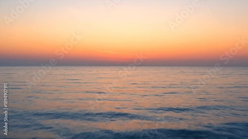 Ocean sunset calm water reflecting vibrant colors of the evening sky